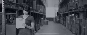 Woman completing an inventory of boxes in a warehouse