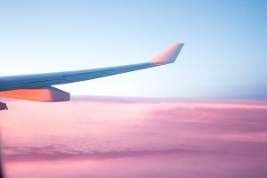 wing of airplane over pink clouds