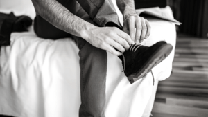 An image of a man putting on a boot.