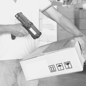 An image of a person scanning an SKU on a package to prepare for shipping
