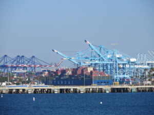 A photo of a port with cargo containers stacked high. The image conveys the importance of efficient and reliable drayage services for transporting freight between ports, warehouses, and distribution centers.